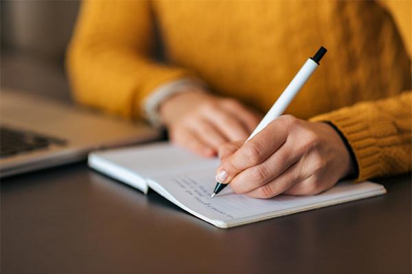 person writing on a notepad